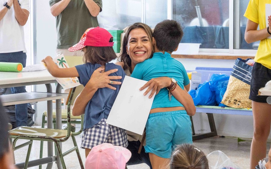 La concejala de Bienestar Social del Ayuntamiento de Arrecife, Maite Corujo, abraza a dos menores durante una edición anterior de los Campamentos Conciliadores de Verano. / Ayuntamiento de Arrecife